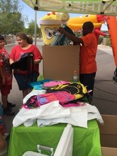 Smoothie Run owner Marcus Moody distributes packpacks to families during the Second Annual Laveen Backpack Drive and Family Fun Day.
