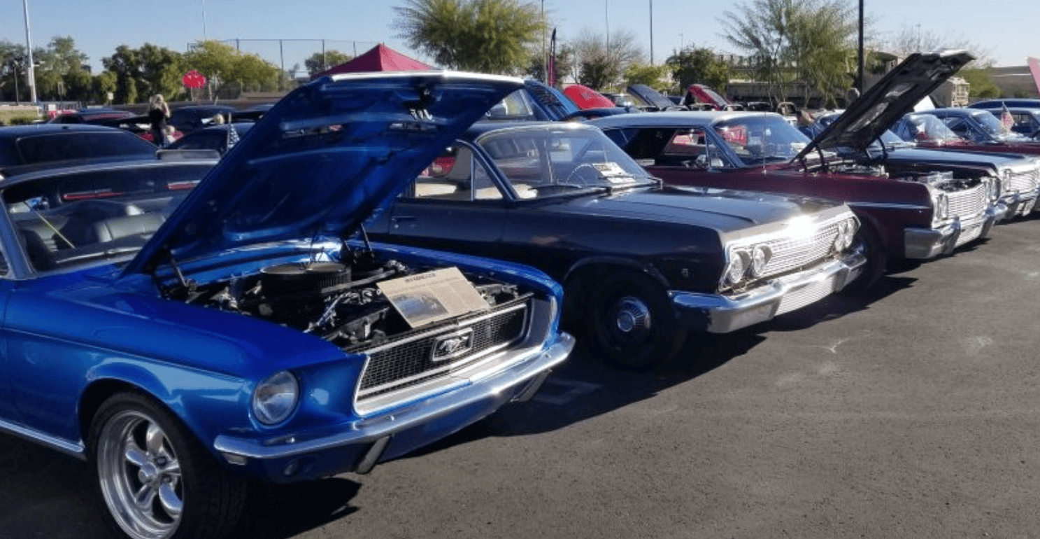 Classic cars displayed with open hoods at the Ahwatukee Car Show